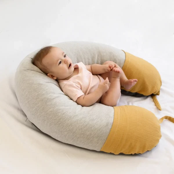bebé estirado encima cojín mostaza